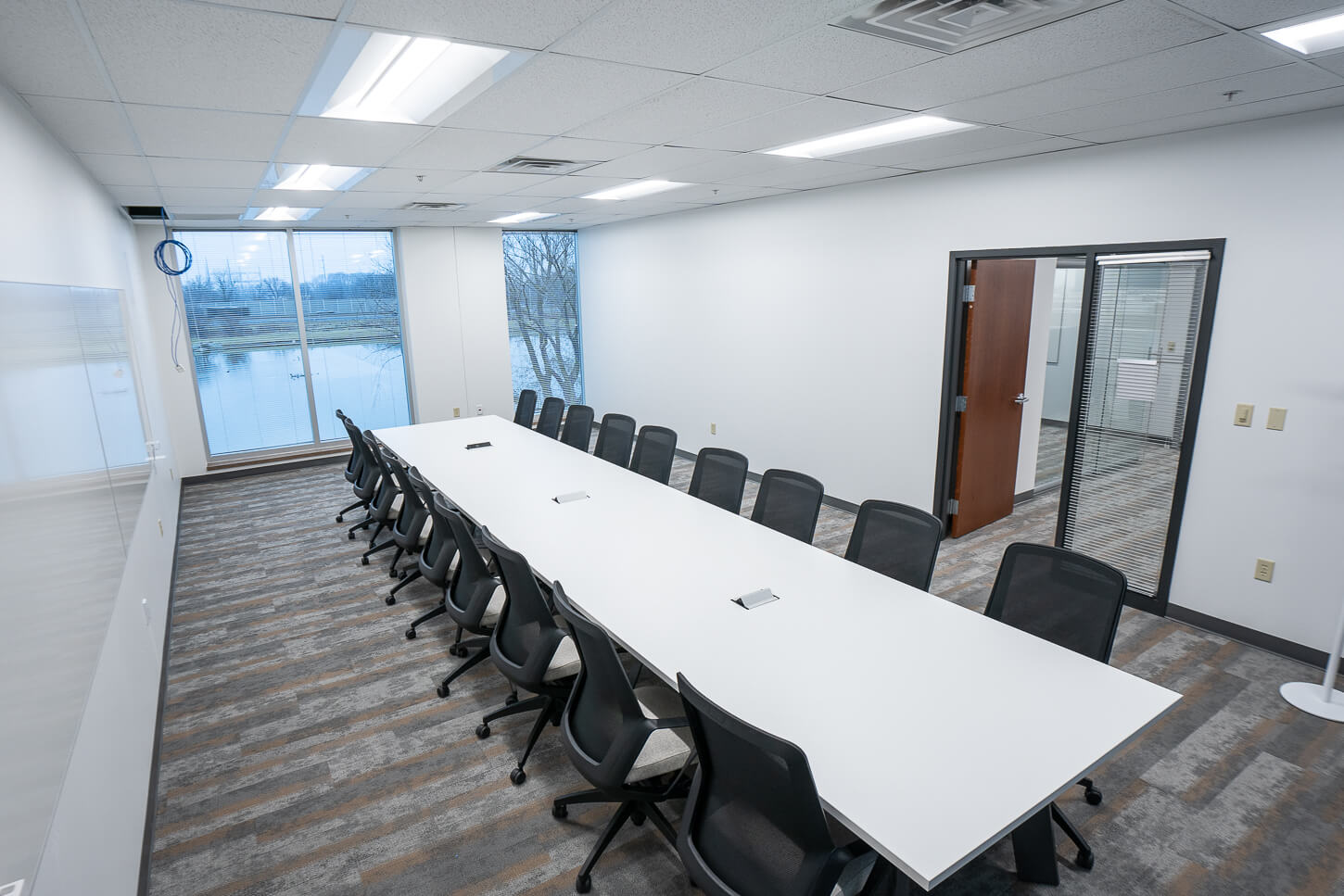 Conference room and table with nice black office chairs in a long narrow workspace