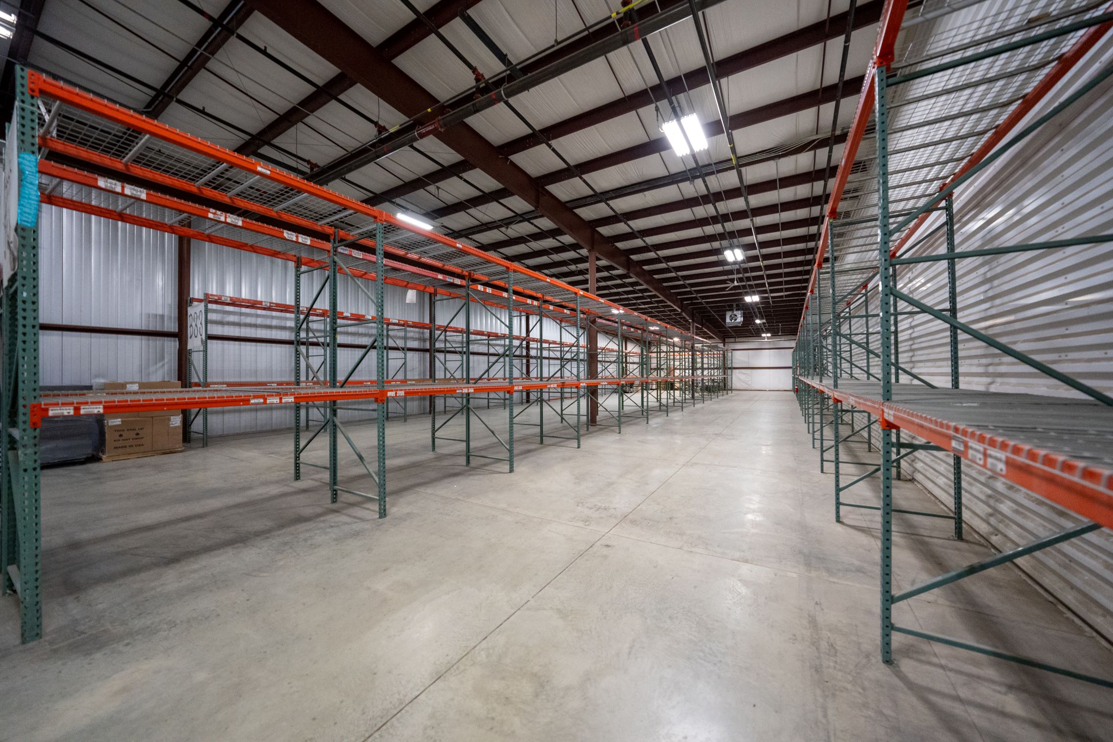 Storage racks colored orange and green in a large warehouse area in Northeast Indiana.